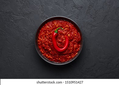 Schezwan Sauce In Black Bowl At Dark Background. Schezwan Sauce Is Indo-chinese Or Sichuan Cuisine Hot Sauce With Red Chilli, Garlic And Ginger.