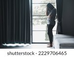 Schizophrenia with lonely and sad in mental health depression concept. Depressed woman standing against with dark room feeling miserable at home . Women are depressed, fearful and unhappy.