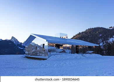 Schoenried, Switzerland - December 18, 2020: The Swiss Alps Landscape Reflected In Blue Hours On Mirage Gstaad By The American Artist Doug Aitken