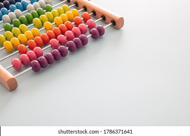 School abacus with colorful beads on pastel blue color background, close up view, copy space. Kids learning count, children math class concept