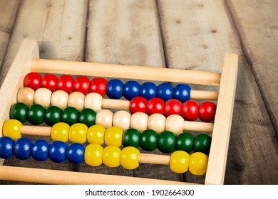 School abacus with colorful beads on wooden desk. Kids learning count,