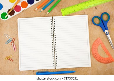 school accessories and checked notebook on wooden table