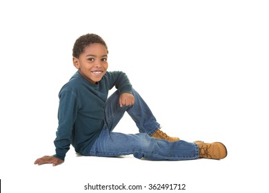 A School Aged Boy Sitting On The Floor Isolated On White