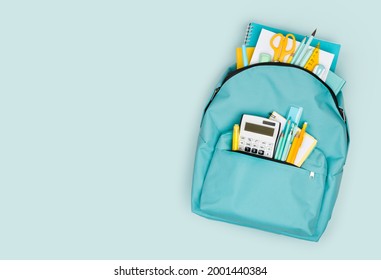 School backpack with different colorful stationery products on blue background - Powered by Shutterstock