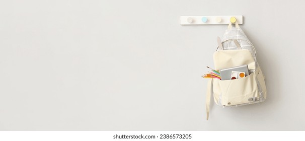 School backpack hanging on light wall. Banner for design - Powered by Shutterstock