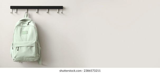 School backpack hanging on light wall. Banner for design - Powered by Shutterstock