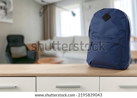 School backpack on an empty table in a sunny living room