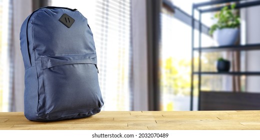 School Backpack On Wooden Desk And School Interior With Big Window