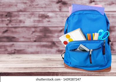 School Backpack with supplies on wooden background - Shutterstock ID 1439287247