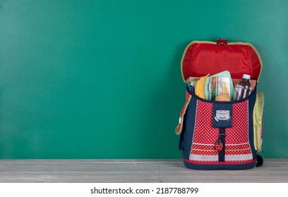 School Bag, White Wooden Table And Blackboard