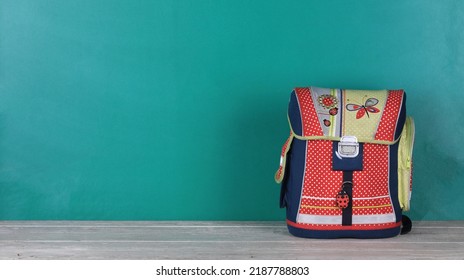 School Bag, White Wooden Table And Blackboard