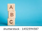 School begginnings. ABC letters of wooden blocks in pillar form on blue background, copy space