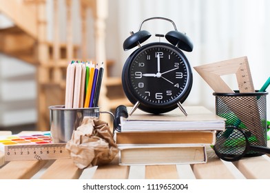 school books with alarm clock on green school board background - Powered by Shutterstock