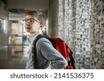 School boy with backpack in corridor