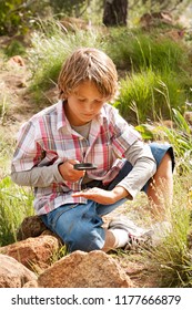 School Boy In Countryside Trip With Spider Bug And Lupe Learning Watching Studying Biology, Nature Outdoors. Child Discovery Expedition Looking At Insect With Magnifying Glass, Recreation Lifestyle.