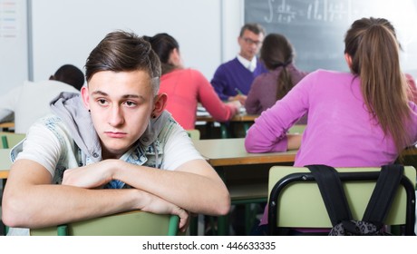 Ã¯Â»Â¿lonely school boy sitting away from classmates and feeling depressed  indoor