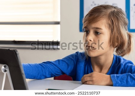 In school, boy using tablet and focusing on learning in classroom. Education, technology, student, studying, digital