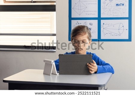 In school, boy using tablet for studying math in classroom. Education, learning, technology, mathematics, student, digital