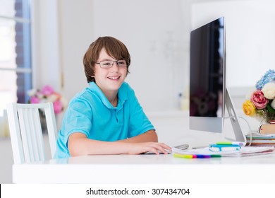 School Boy Working On Personal Computer At Home. Student Doing Homework Using Modern Pc In Classroom. Kids Studying With Digital Devices. Children Study In White Class Room. Child Learning.