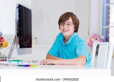 School Boy Working On Personal Computer At Home. Student Doing Homework Using Modern Pc In Classroom. Kids Studying With Digital Devices. Children Study In White Class Room. Child Learning.