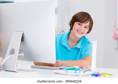 School Boy Working On Personal Computer At Home. Student Doing Homework Using Modern Pc In Classroom. Kids Studying With Digital Devices. Children Study In White Class Room. Child Learning.