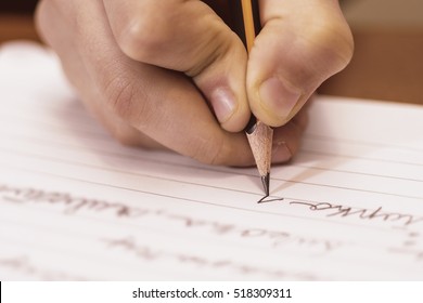 School Boy Writing Close Up. Pencil In Children Hand.