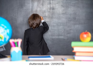 School Boy Writing On Blackboard