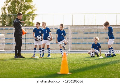 School Boys On Soccer Pitch. Young Coach Talking To Football Players During Training Session. Practice Unit For Youth Sports Team