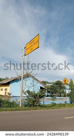 school building with fence and street poles under blue sky