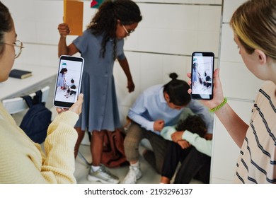 School bullying scene with children recording fight on smartphone camera and posting it to social media - Powered by Shutterstock