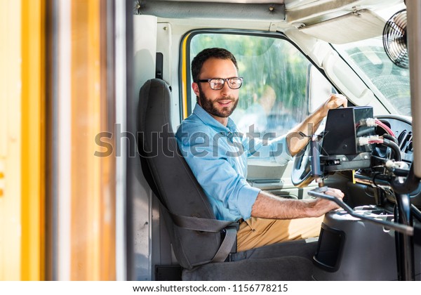 school\
bus driver sitting inside bus and pulling\
lever