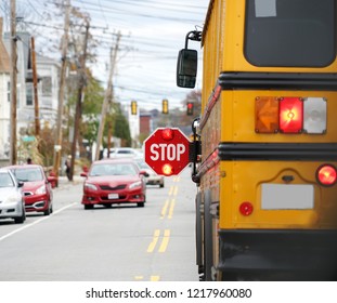 School Bus With Stop Sign Flashing On The Street     