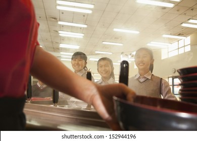 School Cafeteria Worker Serves Noodles To Students