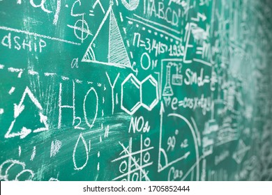 School chalk board is painted with different formulas and signs from the school curriculum. A green blackboard is drawn in chalk as a background. The concept of knowledge and learning. long banner.