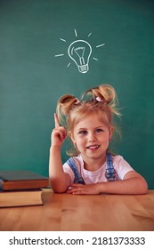 School child (girl) in classroom. Funny kid against green chalkboard. Idea and creativity concept. Copyspace on background. Back to school concept.  - Shutterstock ID 2181373333