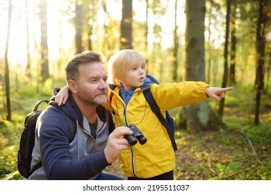 School child and his father hiking together and exploring nature with binoculars at autumn. Little boy and his dad spend quality family time in sunny forest of second summer. Father's Day. Fatherhood. - Powered by Shutterstock