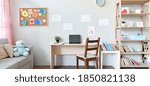 School child room interior space with table, couch, bookcase, books and laptop on table indoors at home apartment background. Children homeschool, online distance remote virtual learning, banner.