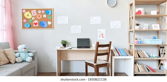 School child room interior space with table, couch, bookcase, books and laptop on table indoors at home apartment background. Children homeschool, online distance remote virtual learning, banner. - Shutterstock ID 1850821138