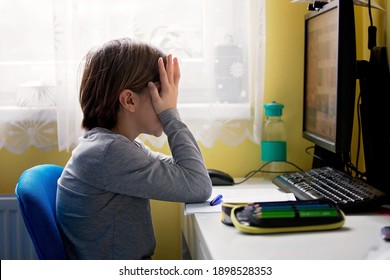 School Child, Sitting At The Table With Laptop, Writing School Tasks While Homeschooling, Pandemic Dintance Teaching Environment