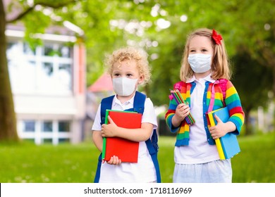 School Child Wearing Face Mask During Corona Virus And Flu Outbreak. Boy And Girl Going Back To School After Covid-19 Quarantine And Lockdown. Group Of Kids In Masks For Coronavirus Prevention. 
