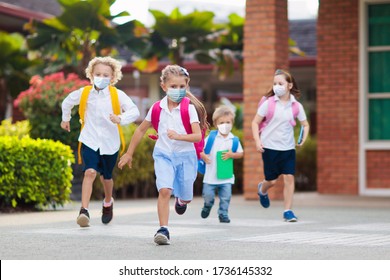 School child wearing face mask during corona virus and flu outbreak. Boy and girl going back to school after covid-19 quarantine and lockdown. Group of kids in masks for coronavirus prevention.  - Shutterstock ID 1736145332