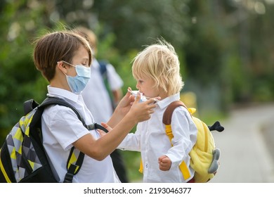 School children, boys, going back to school after the summer vacation, kids going to school wearing medical mask due to coronavirus COVID 19