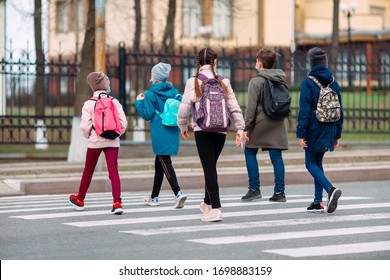 School children cross the road in medical masks. Children go to school - Powered by Shutterstock