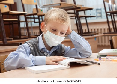 School Children In Medical Face Mask Are Learning In The Half Empty Classroom During Epidemic Of Flu.