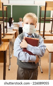 School Children In Medical Face Mask Are Learning In The Half Empty Classroom During Epidemic Of Flu.