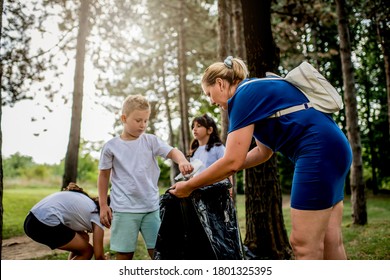 School children picking up garbage together while cleaning public park - Powered by Shutterstock