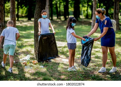 School children picking up garbage together while cleaning public park - Powered by Shutterstock