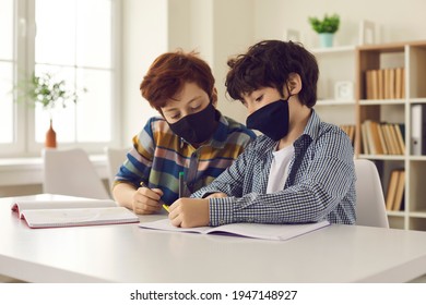 School Children Wear Mouth Covering Face Masks During Coronavirus Infection Outbreak. Creative Students Communicating, Drawing, Writing And Helping Each Other. Two Little Boys Get Distracted In Class