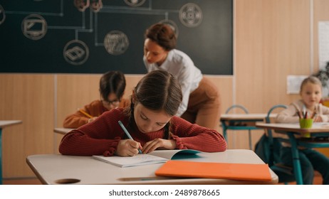 School class lesson children kids studying learning woman teacher female walking teaching little boy child kid rise hand ask help tutor check task study learn helping write talking primary education - Powered by Shutterstock