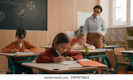 School class lesson children studying learning in classroom woman teacher female tutor walking teaching little boy child kid rise hand ask help question answer study learn write talking education - Powered by Shutterstock